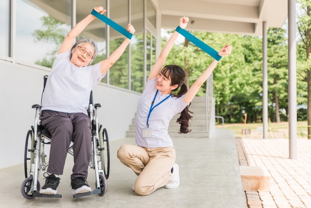 タオルを使ってストレッチをする利用者とスタッフ