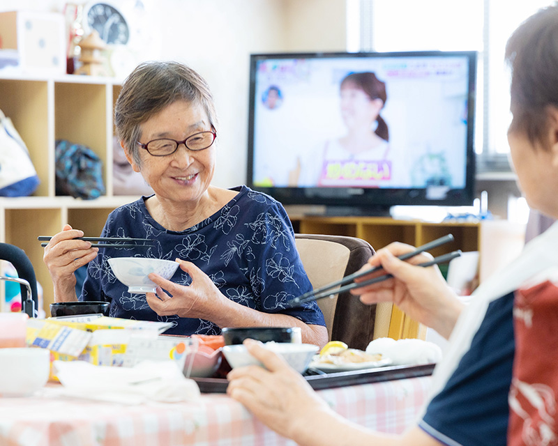 笑顔で食事をする女性利用者