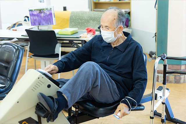 バイクマシーンをこぐ男性利用者